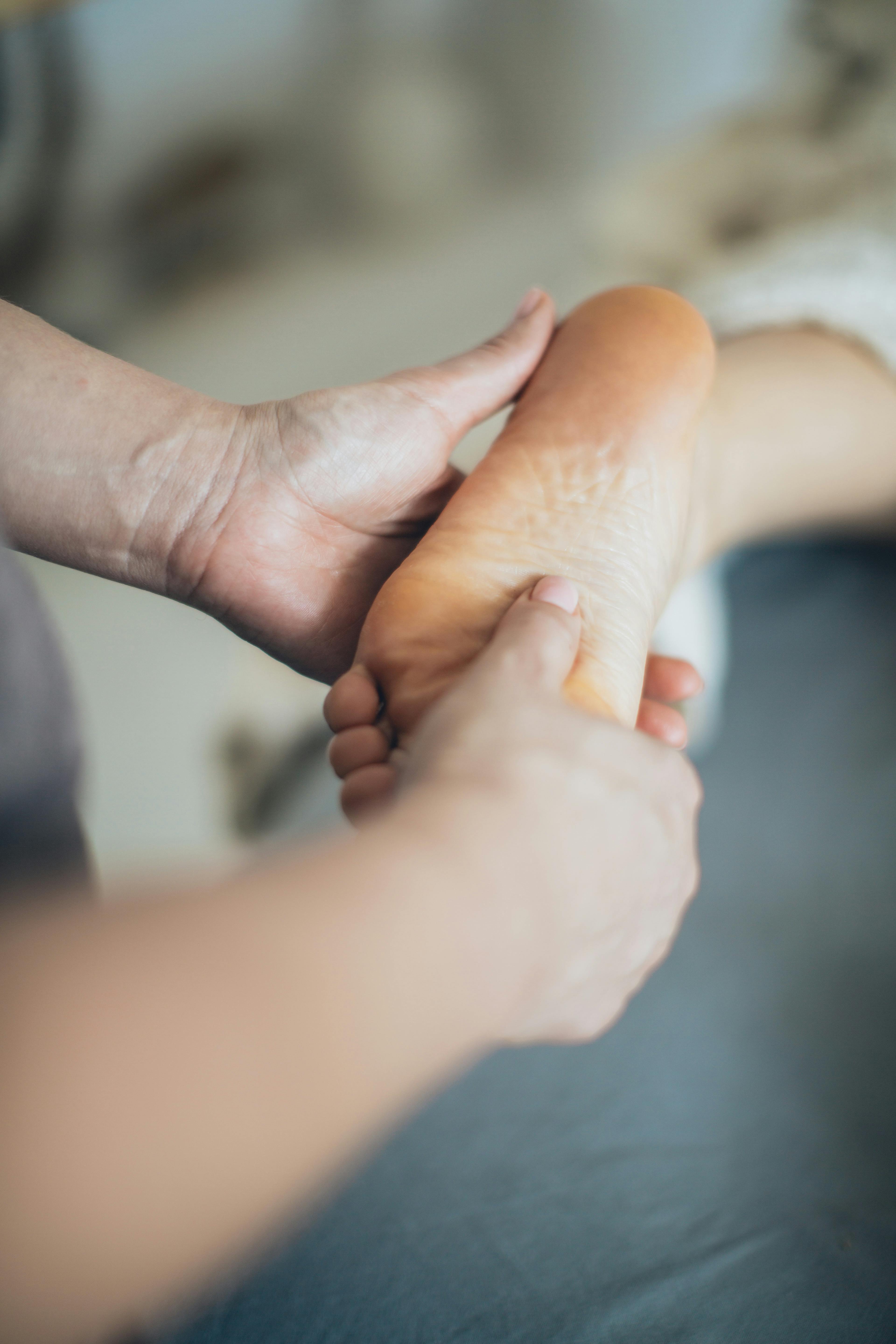 Hands gently cradling a patient's foot during examination